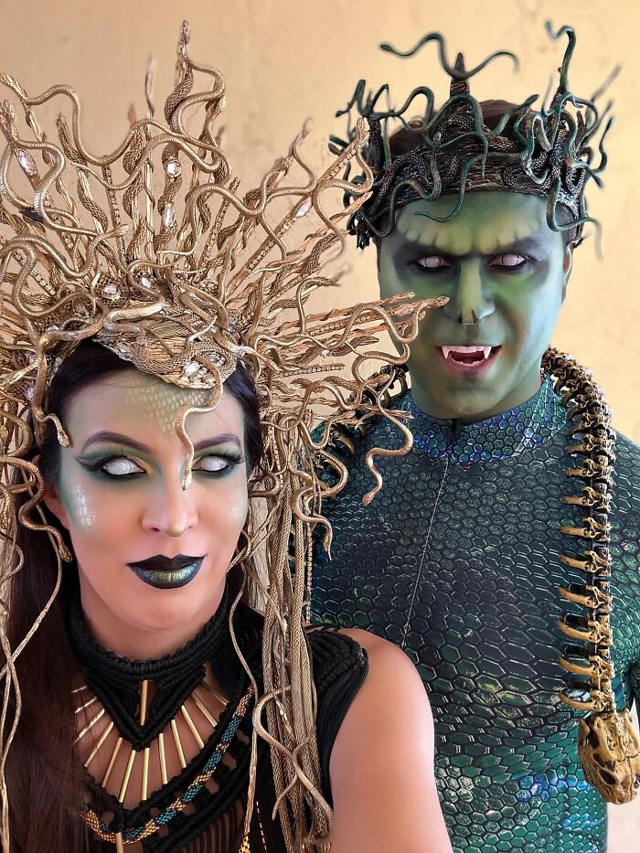 A couple wearing elaborate green and gold Medusa inspired snake headpieces for cool Halloween couples costumes.