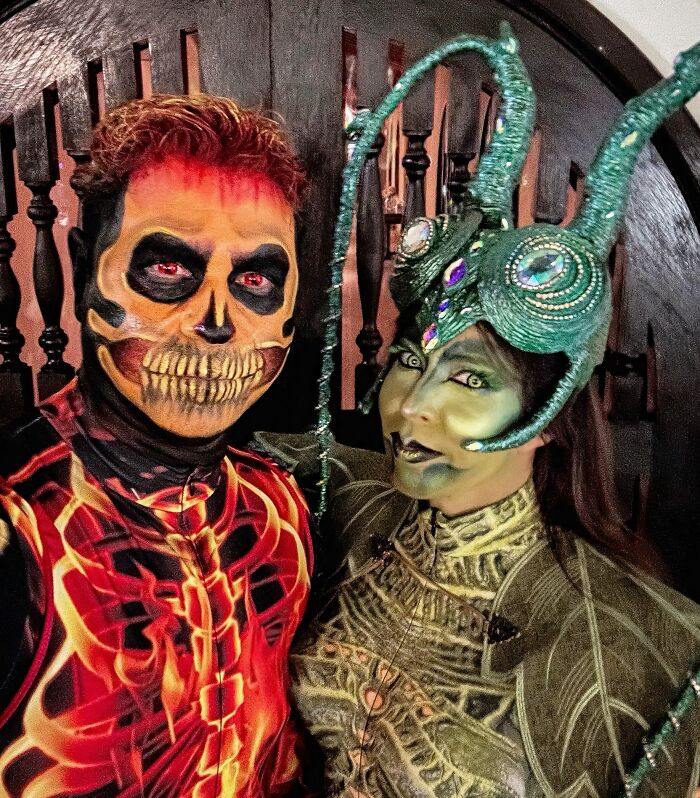 A couple with intricate face paint and headpieces wearing funny cool Halloween couples costumes