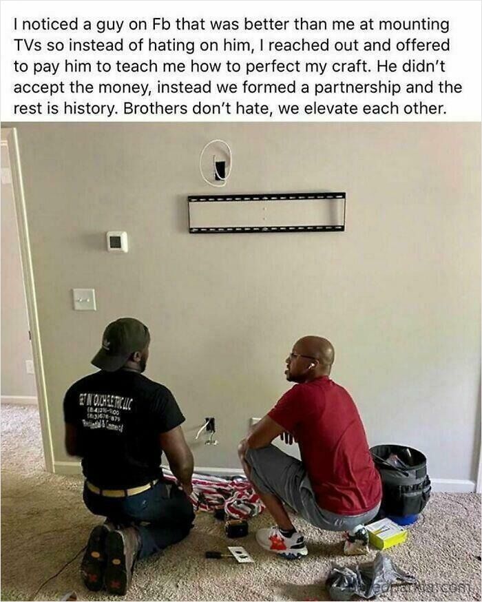 Two men installing a TV together representing wholesome moments shared on the internet.