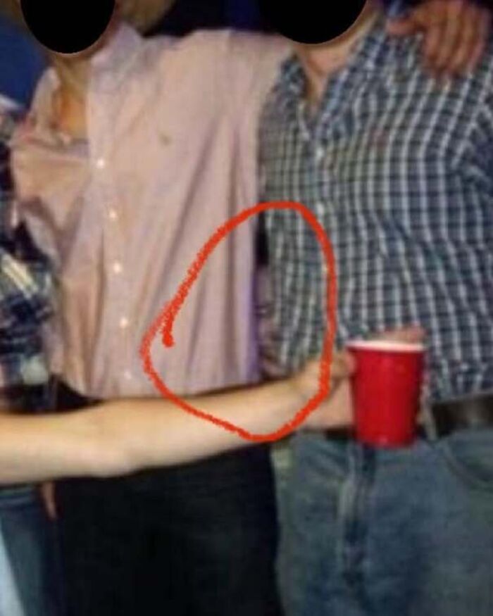 Optical illusion real-life photo showing a detached arm holding a drink like a horror movie scene
