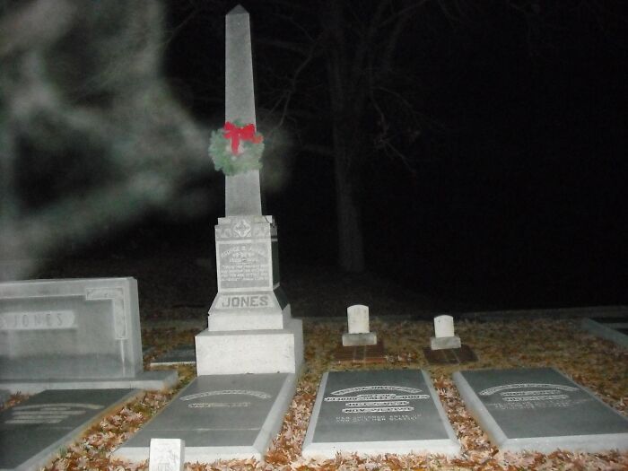 Spooky graveyard at night with a blurred ghostly figure, reminiscent of a horror movie.