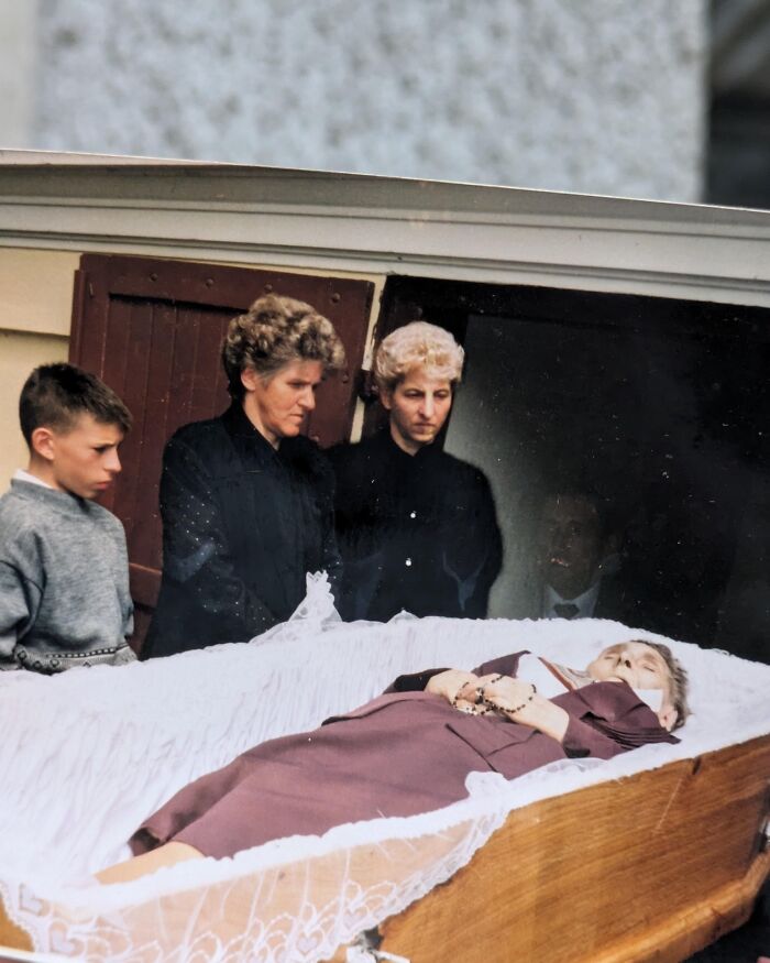 Mourners standing over an open casket during a funeral, captured in real-life photos with a horror movie look.