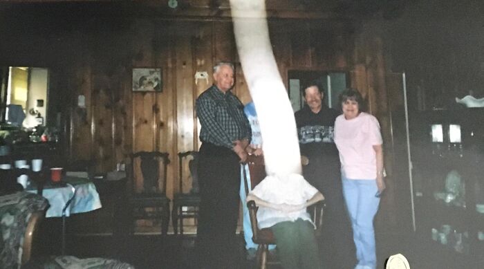 A strange motion blur distorting a person in a family photo like a real-life horror movie