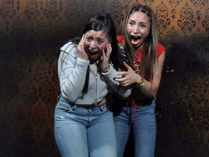 Two terrified women screaming in fear inside a haunted house photo captured