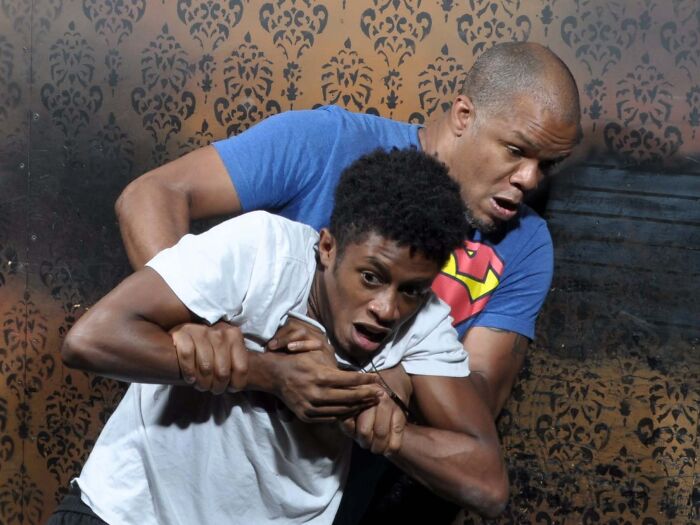 Two men grab each other in panic during a scary haunted house photo moment.