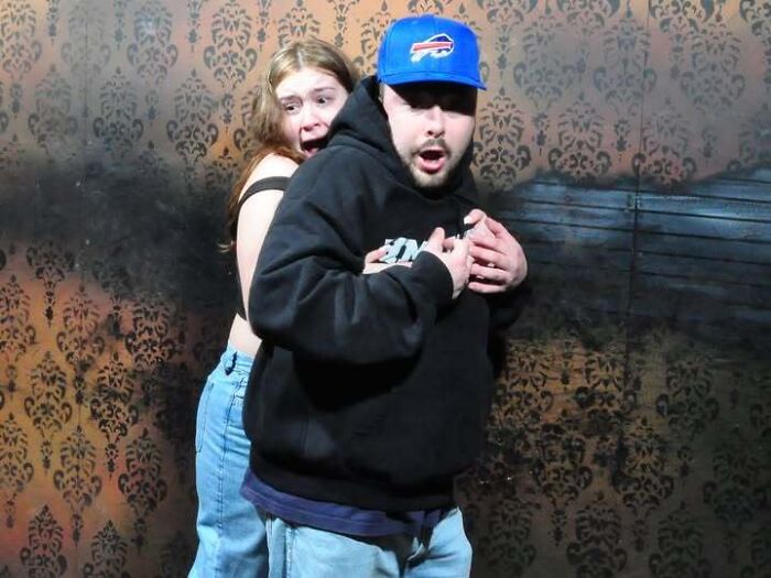 A man and woman showing terrified expressions in one of many hilarious haunted house photos.
