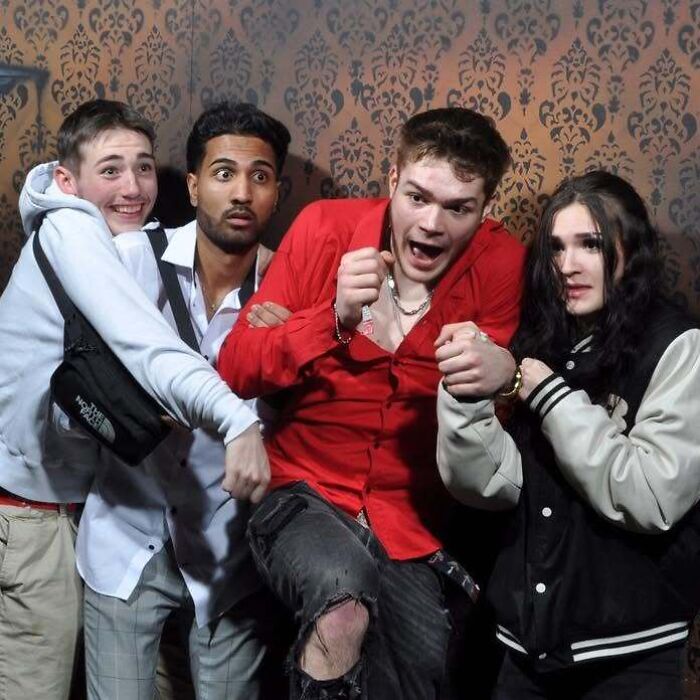 Group of shocked young adults reacting with fear in one of the candid haunted house photos.
