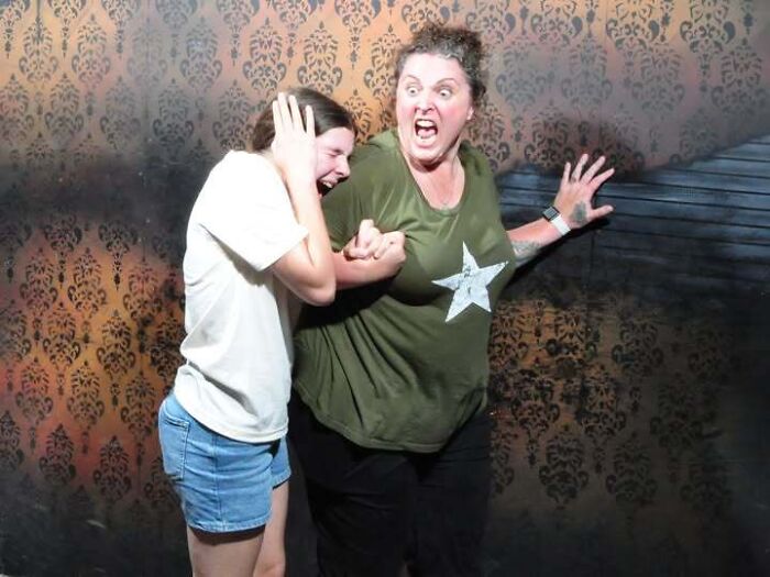 Two women panicking and covering their ears in a haunted house photo