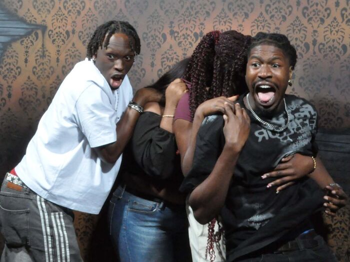 Group of friends screaming in terror inside a haunted house photo