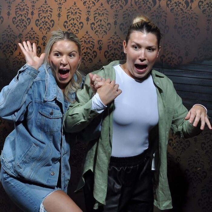 Two women screaming in fear inside a haunted house