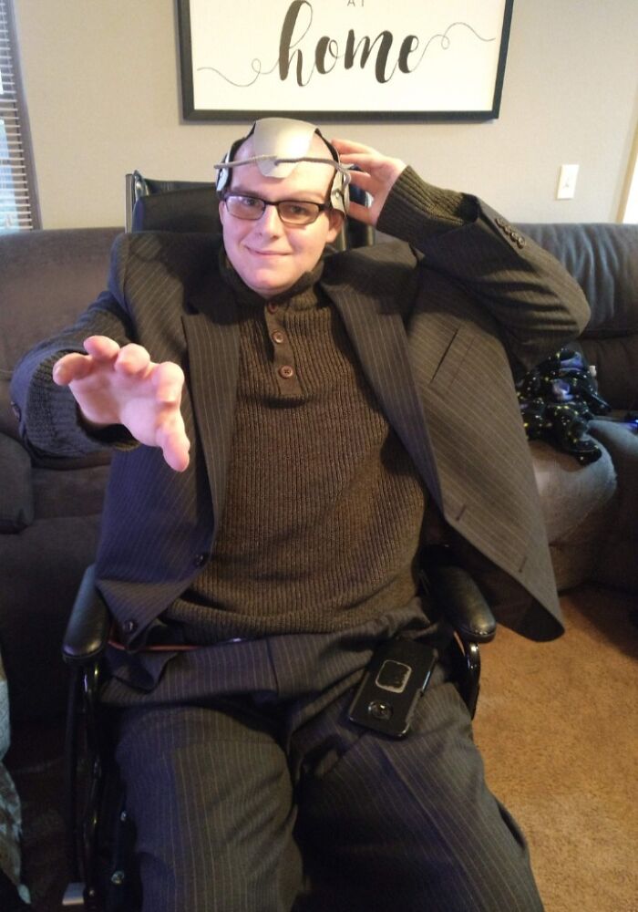 Man in suit and Cerebro helmet in wheelchair posing as Professor X, showing creative people with disabilities