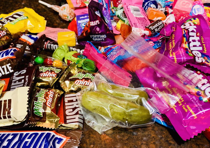 A large pile of Halloween candy featuring chocolate bars and Skittles