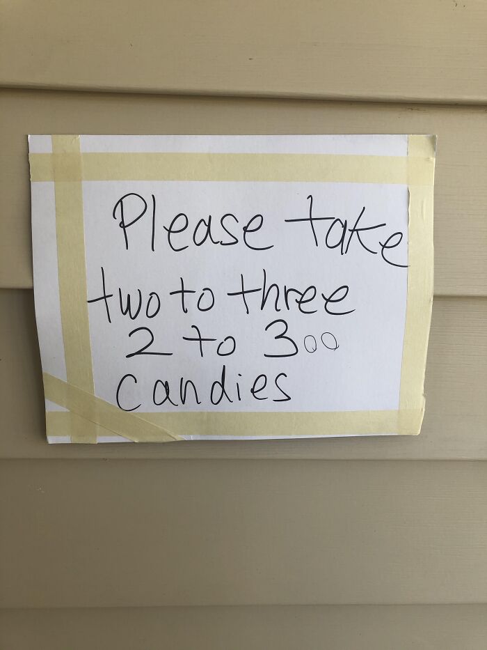 Funny handwritten Halloween sign saying to take 2 to 300 candies.