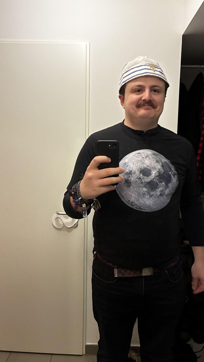 A man taking a mirror selfie wearing a sailor hat and a moon shirt for Halloween photos funny idea