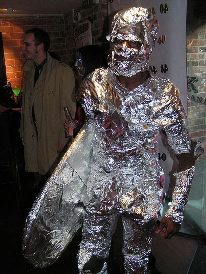Funny Halloween photo of a person covered completely in aluminum foil at a party.