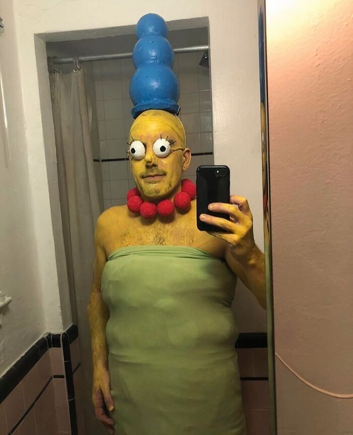 Funny Halloween photo of a person wearing a homemade Marge Simpson costume in a bathroom.