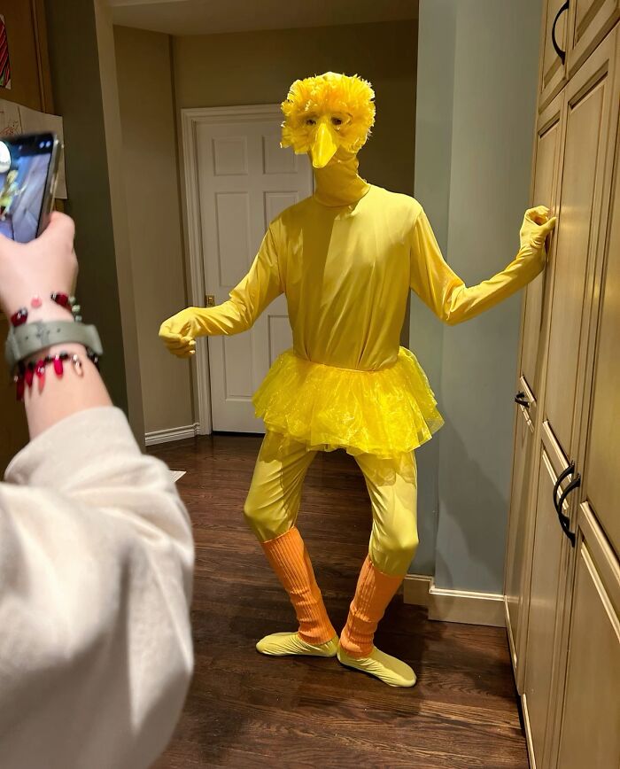 Funny Halloween photo of a person posing in an awkward DIY yellow bird costume.