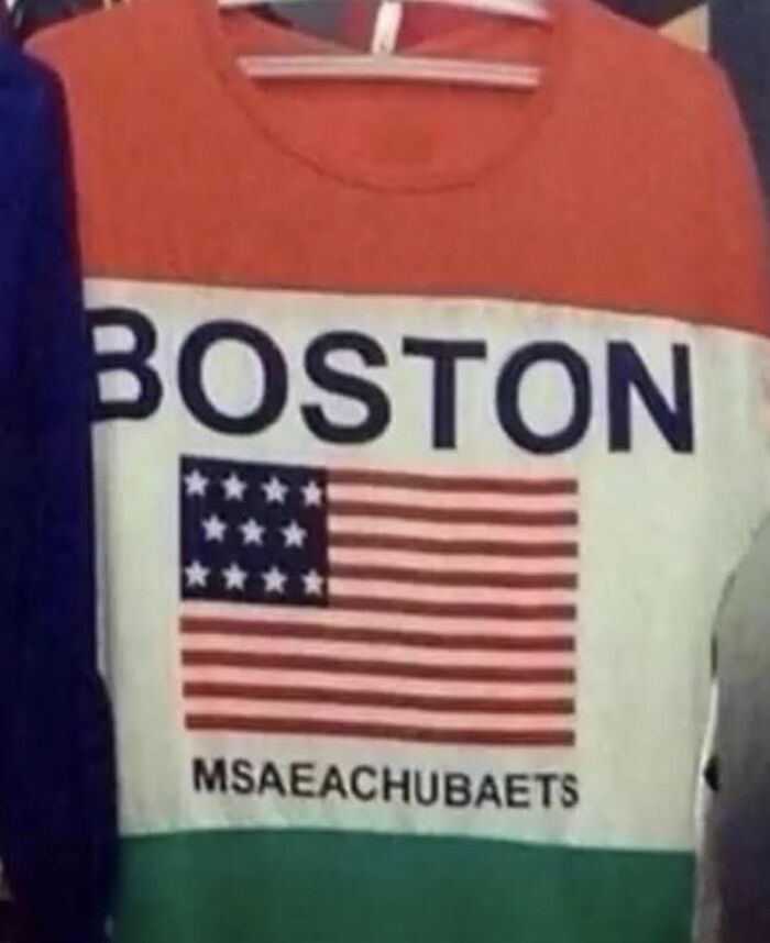 Red and white sweatshirt with spelling fails printed as MSAEACHUBAETS under the word Boston and flag