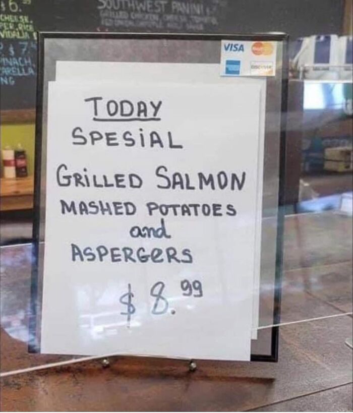 Menu sign showing spelling fails listing salmon with Aspergers instead of asparagus for eight dollars