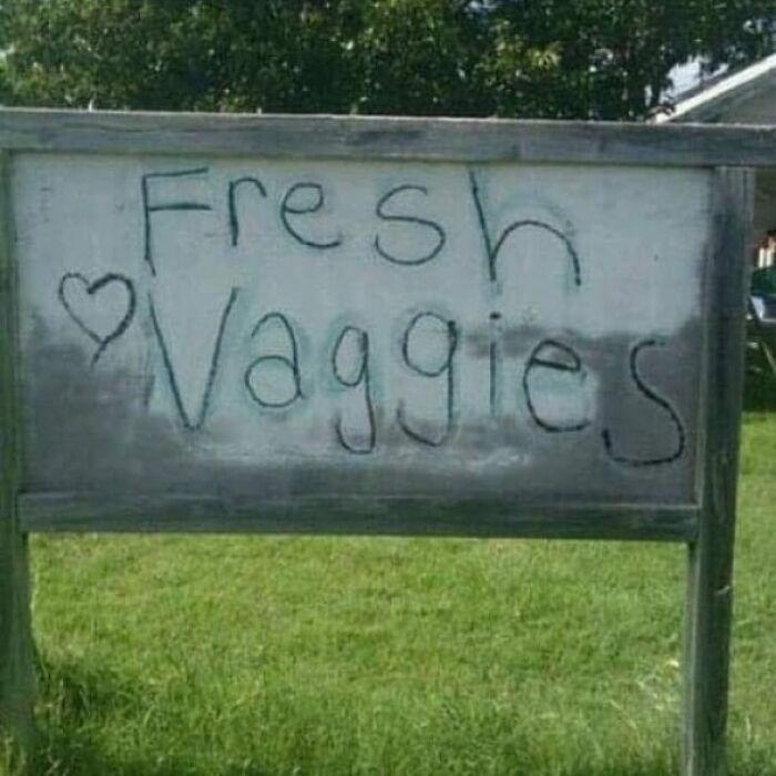 A wooden sign reading Fresh Vaggies with a heart, an example of funny spelling fails on a farm stand.