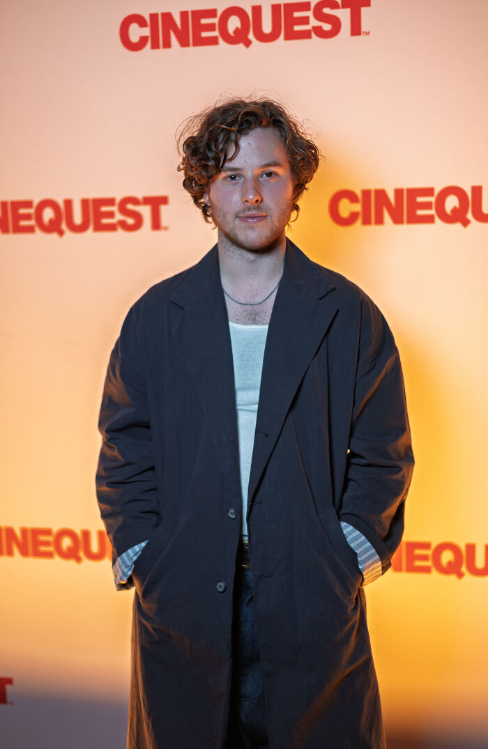 Actor Nolan Gould wearing a dark coat and posing at a Cinequest red carpet event