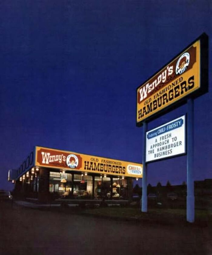 A classic Wendy's restaurant exterior illuminated at night, featured in old photos of America.