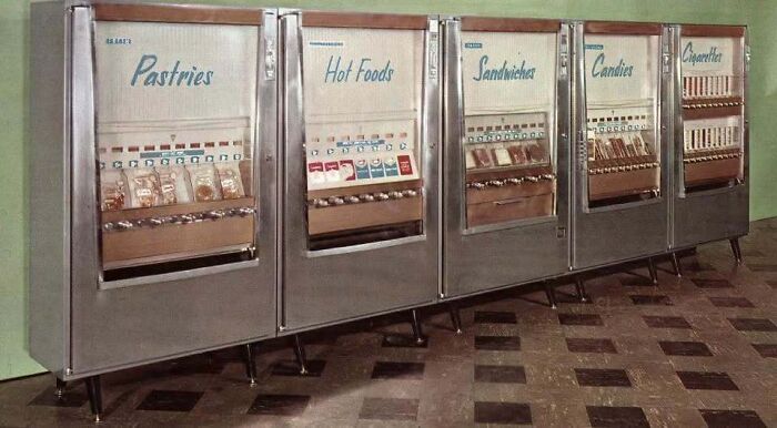 Row of vintage stainless steel food vending machines in old photos of America.