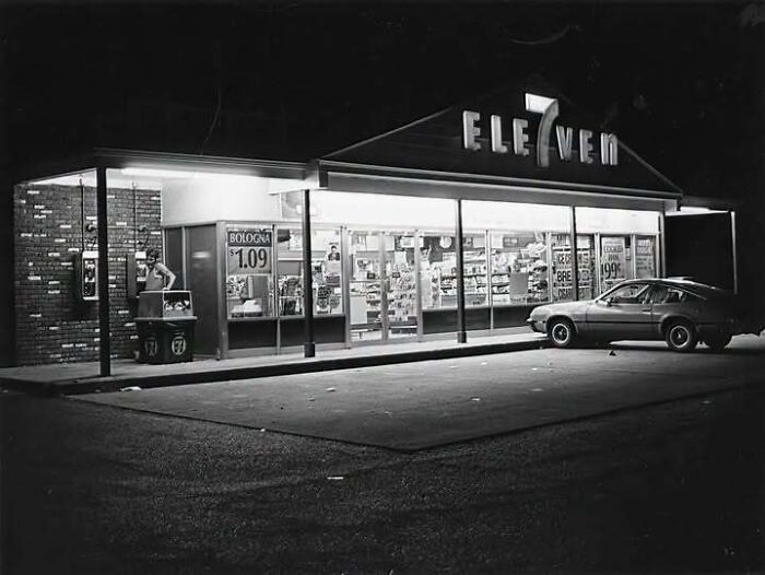 Exterior view of a 7-Eleven store at night in old photos of America