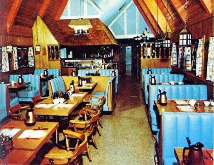 Cozy retro diner interior captured in old photos of America showing wooden walls and blue booths.