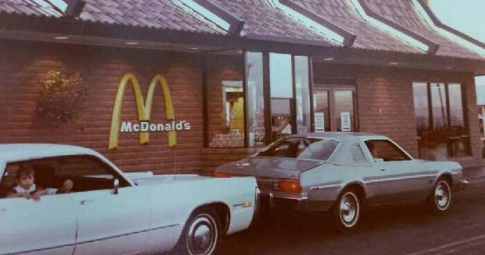Drive-thru window at a vintage McDonald's from old photos of America featuring classic cars.