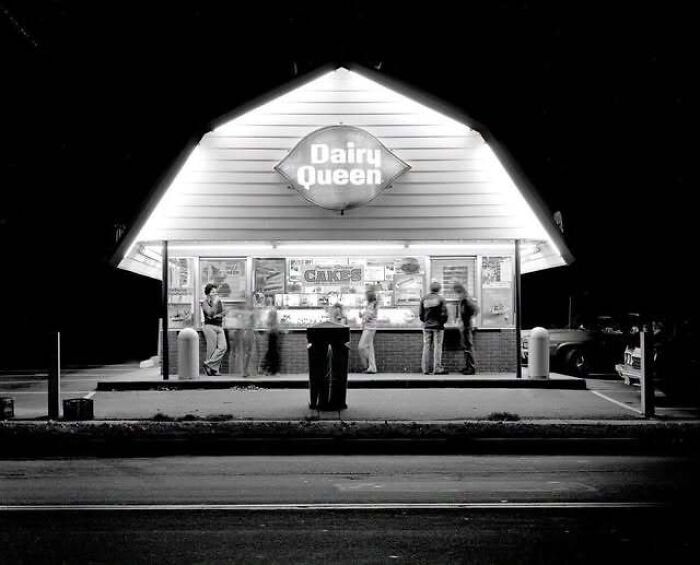 Black and white photograph of an illuminated vintage Dairy Queen building, capturing old photos of America.