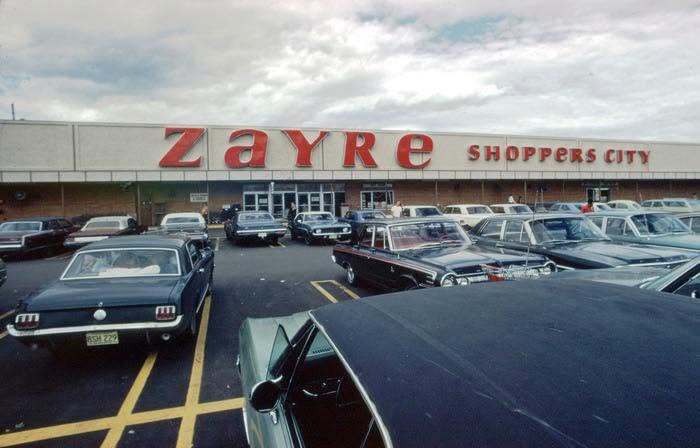 Old photo of a Zayre Shoppers City store parking lot with classic cars in America