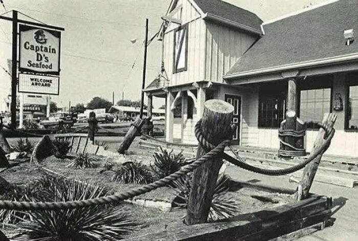 A black and white old photo of America showing the exterior of a vintage Captain D's Seafood restaurant.