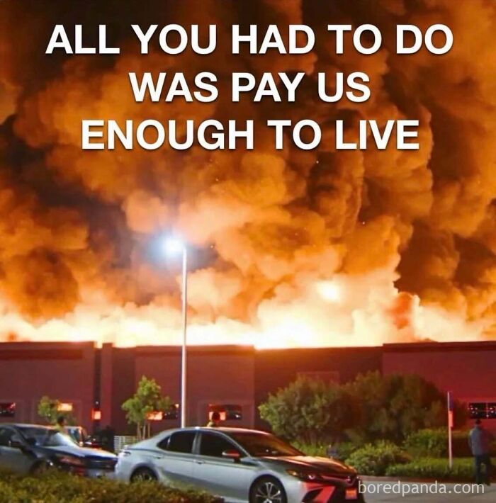 Large building engulfed in flames with text overlay representing commentary in dark dystopian memes.