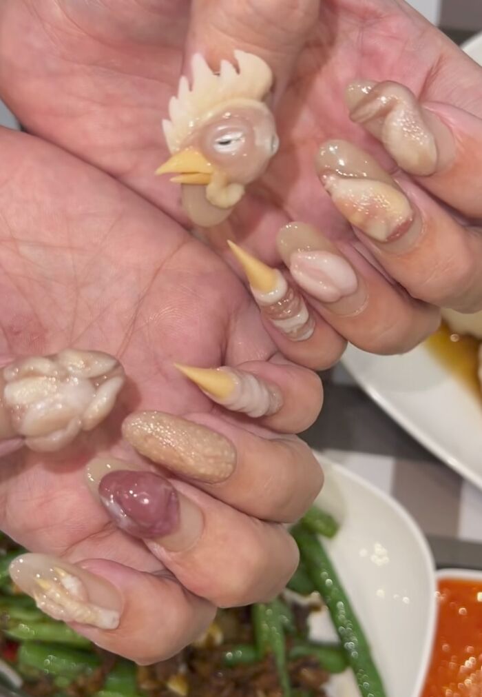 Awful creations displaying custom nail art styled to look like raw chicken parts and a chicken head.
