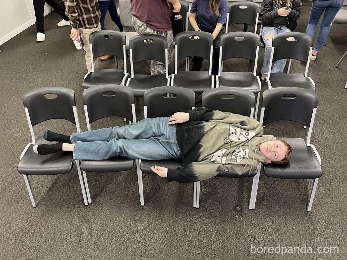 A boy lying across five plastic chairs, highlighting funny posts about avoiding the metric system.