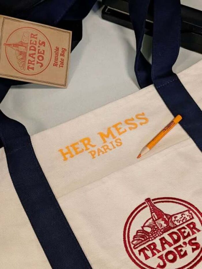 A Trader Joe's canvas tote bag embroidered with HER MESS PARIS, showcasing an error.