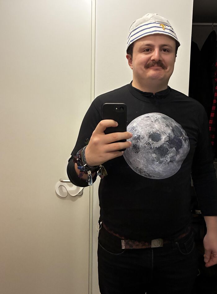 A man taking a mirror selfie wearing a sailor hat and a moon shirt for Halloween photos funny idea