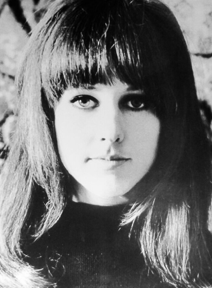 Black and white close-up portrait of singer Grace Slick with dark hair and bangs.