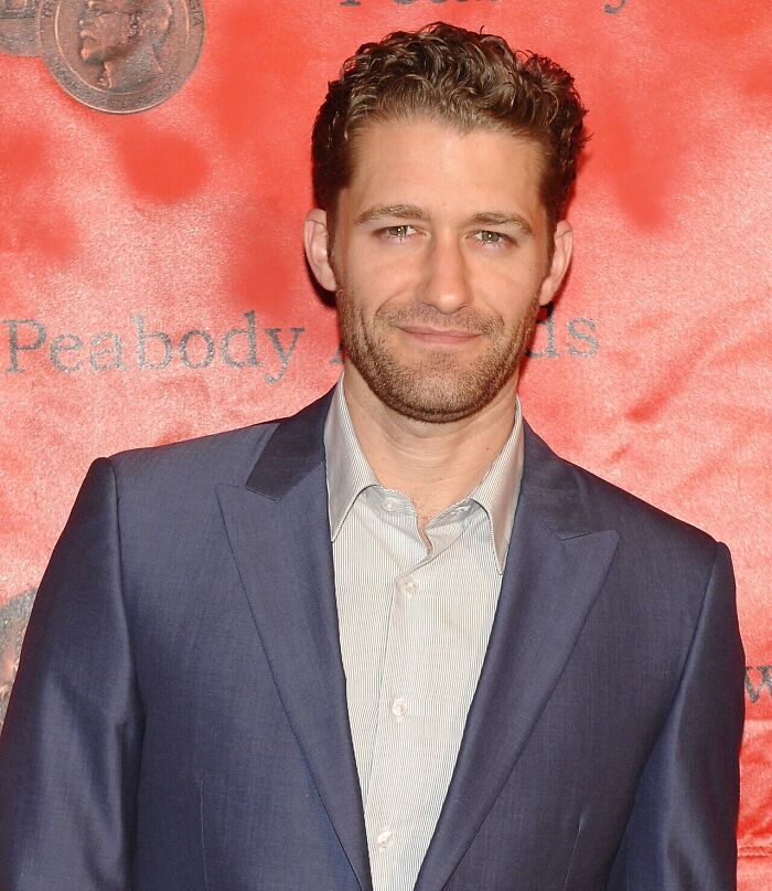 Actor Matthew Morrison wearing a blue suit jacket smiling on a red carpet event
