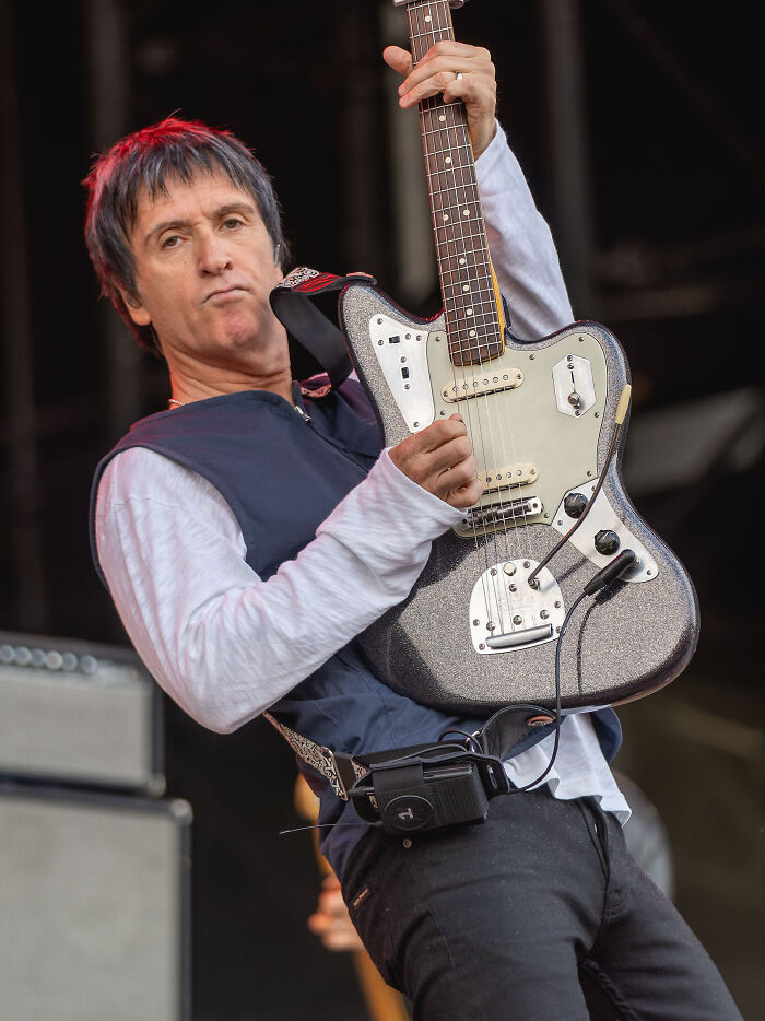 Musician Johnny Marr plays an electric guitar live on stage during a concert performance