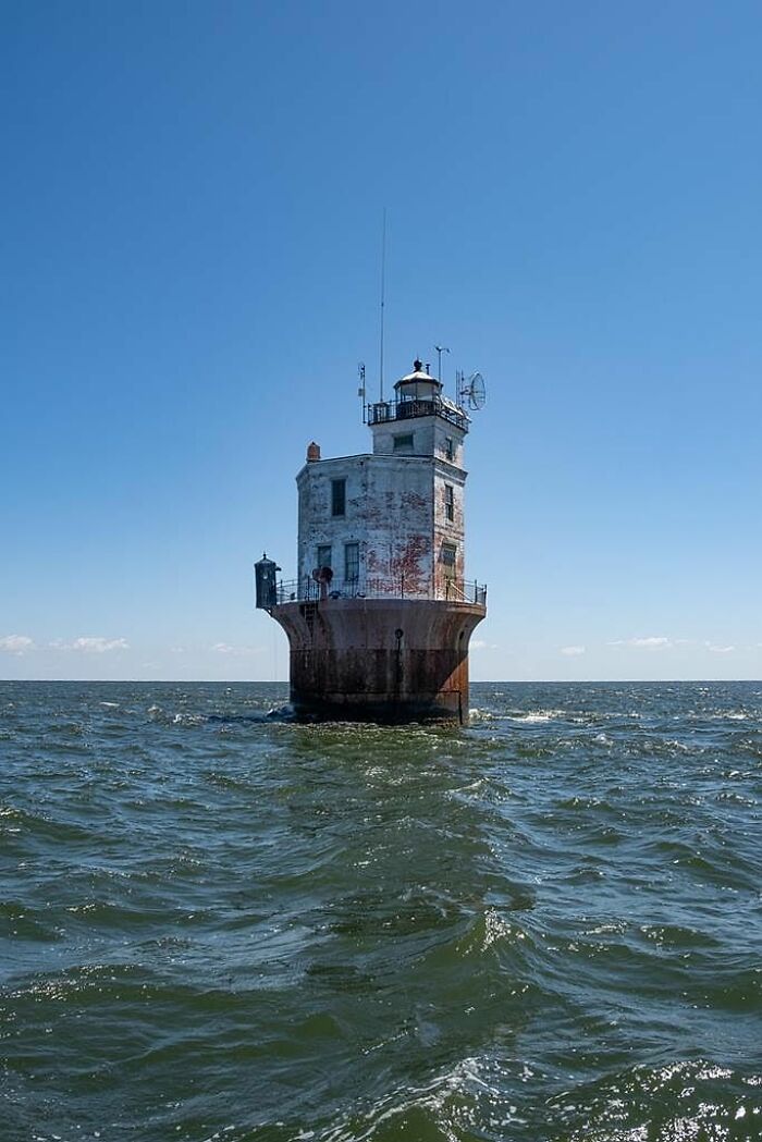 Isolated lighthouse strange building standing on sea waters