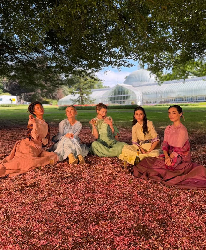 Actresses in period gowns enjoying a picnic on the grass, featuring a Hollywood Actress.