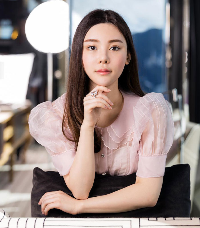 Portrait of woman in sheer pink blouse with long hair resting chin on hand Portrait of woman in sheer pink blouse with long hair resting chin on hand