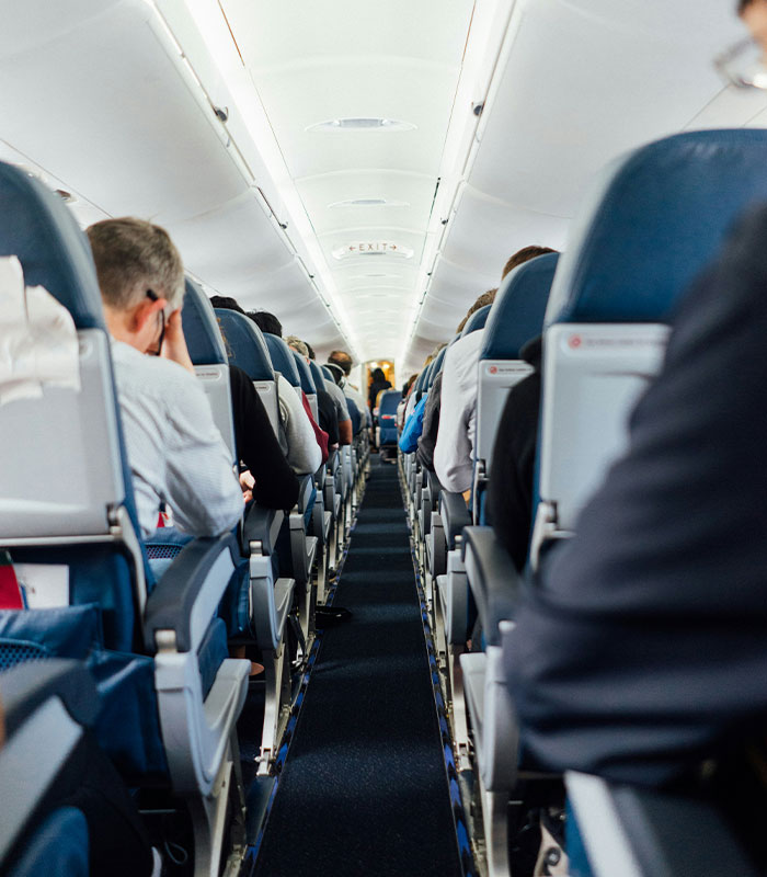 Airplane interior with passengers seated on a flight Airplane interior with passengers seated on a flight
