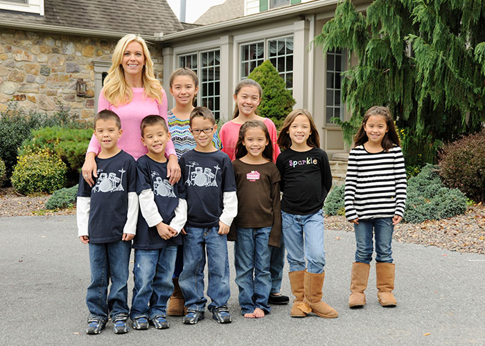 Kate Gosselin posing outdoors in front of a house with her young children Kate Gosselin posing outdoors in front of a house with her young children
