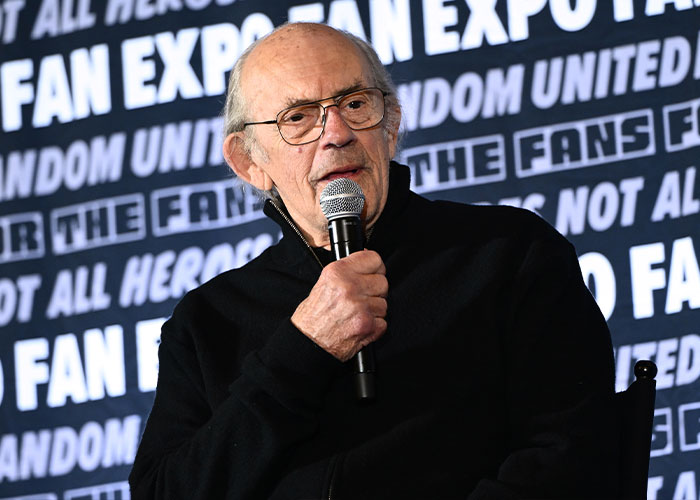 Actor Christopher Lloyd speaking into a microphone during a panel at Fan Expo Actor Christopher Lloyd speaking into a microphone during a panel at Fan Expo
