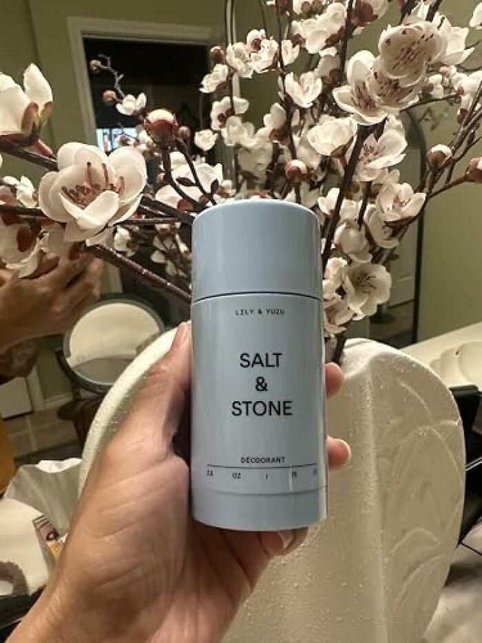 Hand holding a Salt and Stone natural deodorant stick, popular during Amazon Big Deal Days