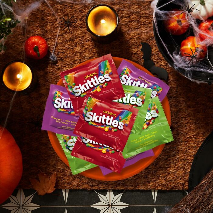 A bowl filled with colorful Skittles packs, making them one of the best Halloween candies for trick-or-treating.