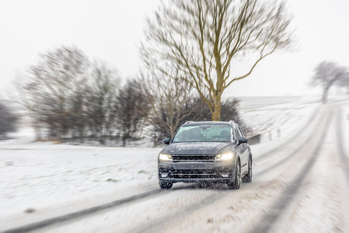 Car driving down a snowy winter road, related to personal divorce stories and cold breakups.
